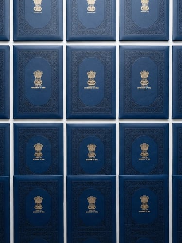Flat-lay arrangement of official Indian certificate folders, high-contrast blue and white tones, bright even office lighting, sharp focus, 35mm