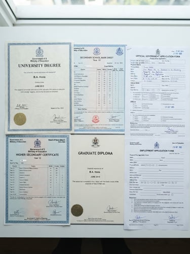 Flat-lay arrangement of neatly organized educational certificates, high school marksheets, and official government application forms on a clean white desk, bright even daylight, professional 35mm photography