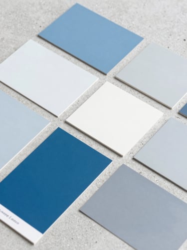 Meticulous flat lay of modern paint swatches in shades of blue, white, and cool gray on a clean concrete surface, bright natural daylight, sharp focus, 35mm