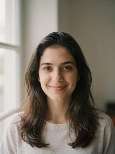 Warm portrait of Christiane Fernanda looking directly at the camera with a gentle, welcoming smile, soft natural window light, muted earthy tones, shallow depth of field.