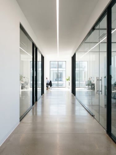Bright, sunlit modern office corridor, clean architectural lines, minimalist design, pristine glass partitions, natural daylight, sharp focus, 35mm