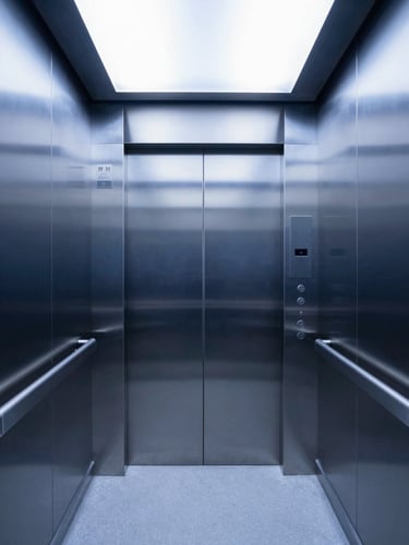 Symmetrical interior perspective of a sterile hospital elevator, seamless brushed stainless steel walls, antimicrobial handrails, soft cool white architectural lighting.
