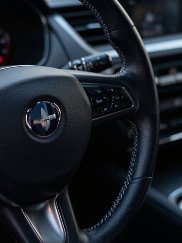 Tight macro shot of a pristine leather-wrapped steering wheel with subtle silver stitching, moody low-key lighting, dark navy reflections, 35mm lens