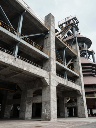 Extreme wide-angle shot of monolithic concrete and structural steel industrial architecture, cool overcast daylight, deep controlled shadows.