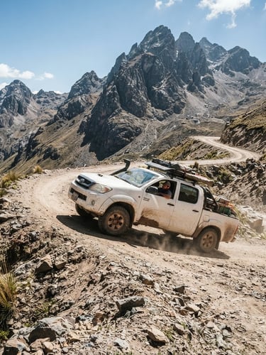 Wide-angle portrait shot of a white Toyota Hilux 4x4 navigating a steep, dusty Andean mountain road under harsh high-altitude daylight, rocky peaks in the background.
