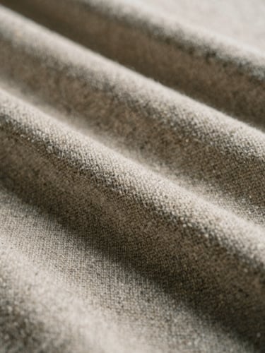 Close-up of premium heavy wool textile texture in oatmeal and charcoal tones, soft natural daylight with subtle shadows, architectural lines, 35mm film style