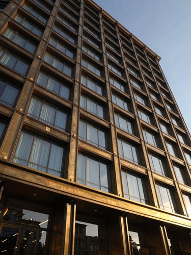 Dramatic architectural detail of a luxury business hotel facade in Turkey at golden hour, warm brass lighting reflecting on steel and glass, professional wide-angle shot