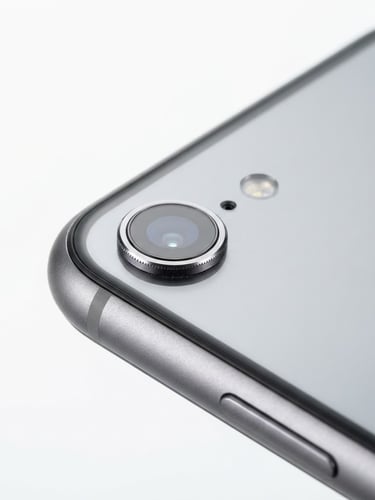 bright high-key product photography, seamless white backdrop, crisp studio light, macro details, 85mm lens, close-up of a pristine smartphone edge and camera lens