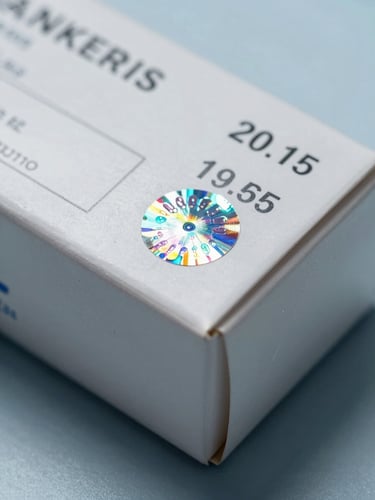 A macro, high-contrast photograph of a sealed pharmaceutical box showing technical batch numbers and a holographic security seal under cool, sterile clinical lighting.