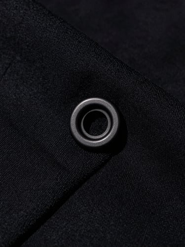 Extreme macro close-up of heavy-weight 400 GSM black cotton fabric texture, showcasing the dense weave and custom matte-black steel hardware under harsh direct studio light.