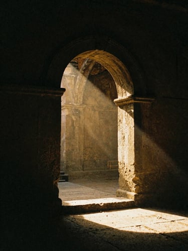 Chiaroscuro film photography of a solitary stone archway in a dark, ancient ruin, a single beam of dramatic golden sunlight piercing the gloom, 35mm grain.