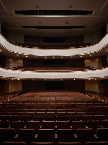 Cinematic architectural wide-angle of a massive empty modern auditorium, dramatic stage lighting, deep shadows, 35mm.