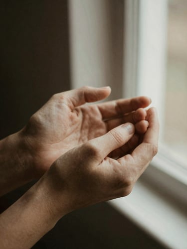 Close-up of hands holding, warm natural window light, muted earthy tones, shallow depth of field, 35mm film feel