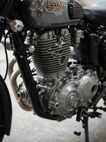 Close-up of Royal Enfield engine block and cylinder head from the left side, diffused north-facing light, casting fins and oil cap visible, bare concrete floor in background, no rider