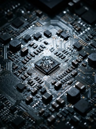 Macro close-up of a complex multilayer printed circuit board, cool laboratory light reflecting off metallic traces, deep shadows, sharp industrial photography