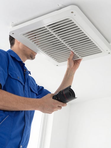 Bright clean commercial photography, close-up of a professional technician in a clean uniform inspecting a pristine air duct grate under soft natural light, sharp focus, 35mm lens.