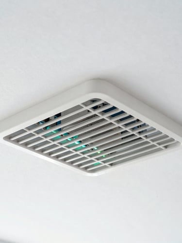 A close-up shot of a clean, pristine metallic ventilation grate mounted on a bright white ceiling, soft green and blue ambient light reflection, sharp focus