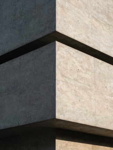 Minimalist architectural corner of a concrete and steel building, sharp geometric shadows under bright afternoon sun, 35mm photography