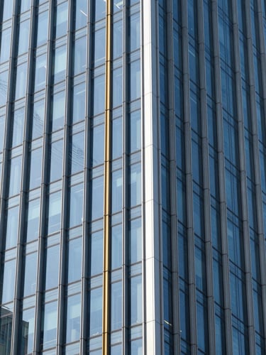 Sharp architectural photography of a modern glass skyscraper facade reflecting blue sky, high-contrast daylight, crisp clean focus, 35mm
