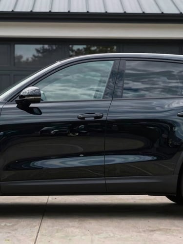 Side profile of a premium vehicle with flawless dark tinted windows parked on a clean modern driveway in Essex, crisp reflections