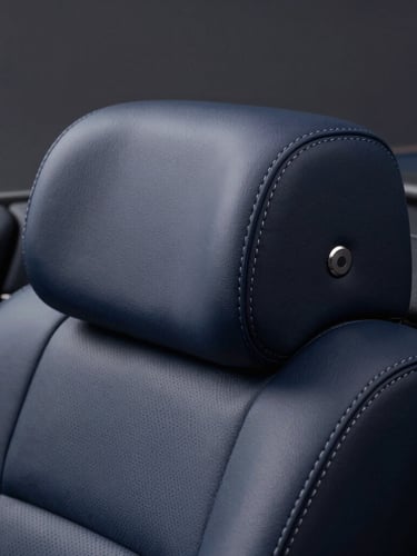 Close-up of elegant leather stitching on a luxury car dashboard, soft studio lighting, deep navy tones, sharp focus, 50mm
