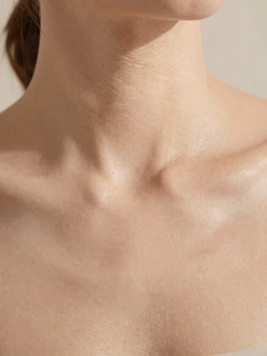 Close-up of clean skin texture with soft natural daylight, warm sand tones, minimalist clinical aesthetic, 35mm photography