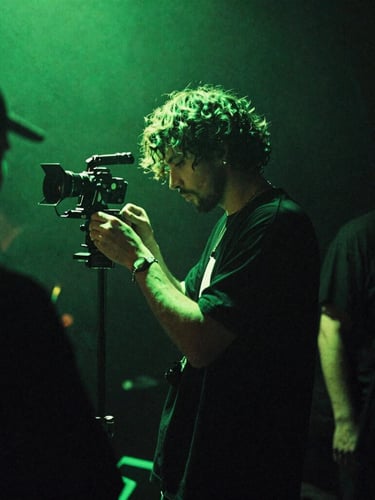 Gritty backstage photography, low-key neon green stage lighting, artist preparing in the shadows with 35mm film grain, atmospheric.