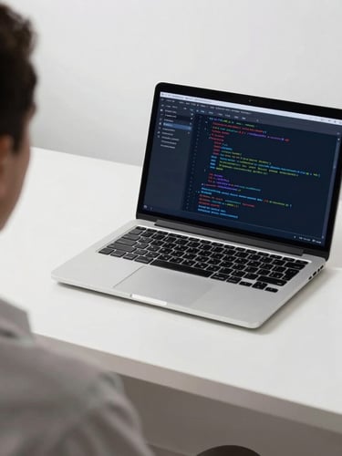 Over-the-shoulder shot of a clean minimalist desk with a laptop displaying code and analytics, cool daylight with subtle blue screen-glow, sharp focus, 35mm lens