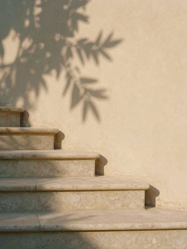 A minimalist stone staircase with exactly three steps, warm stucco wall background, soft olive leaf shadows, warm afternoon sunlight, architectural detail, 35mm