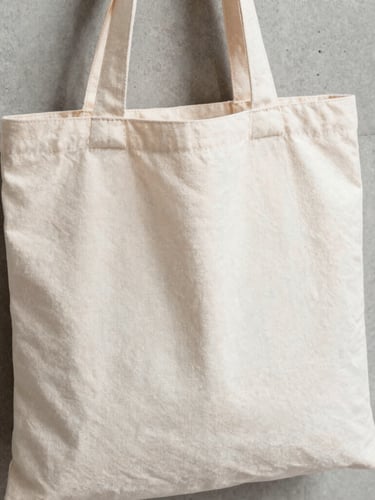 Close-up of a high-quality organic cotton tote bag with a minimalist screen-printed graphic, natural daylight, sharp focus, neutral concrete background.