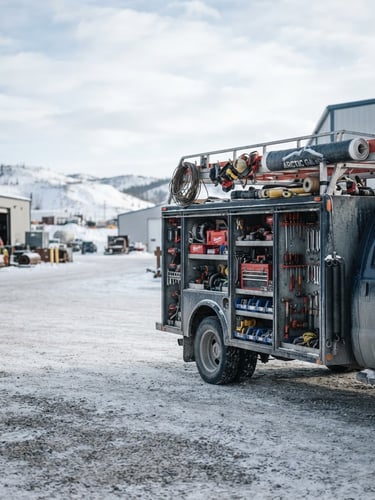 Wide panoramic shot of a fully stocked Arctic Garage Door's service truck, organized tools and heavy-duty parts visible, bright natural outdoor daylight, crisp cool tones, high contrast, shallow depth of field, 50mm lens, right third of frame.