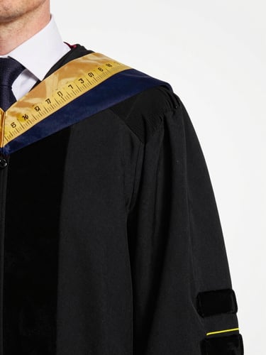 Frontal close-up of an academic gown sleeve and hood junction under studio daylight, showing stripe placement markings and hood width measurement tape, clean white background, precise editorial framing