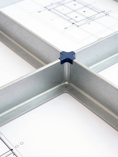 Extreme close-up of a structural joint connecting steel beams, architectural blueprint lines visible in background, bright white studio lighting, sharp focus.