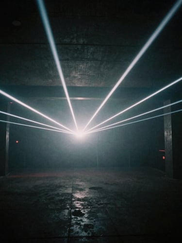 Abstract light beams cutting through heavy haze in a raw concrete subterranean room, dark atmospheric club photography, high contrast, 35mm