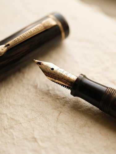 Close-up macro detail of a vintage fountain pen resting on heavy, warm cream cotton paper, soft indirect window light, rich muted tones, shallow depth of field, 35mm