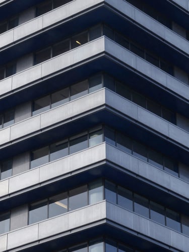 Crisp studio lighting on a modern architectural structure with clean geometric lines, steel and glass elements, deep navy tones, premium corporate aesthetic