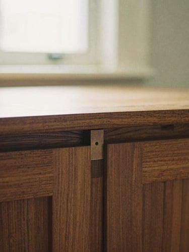 Detailed close-up of mortise and tenon wood joinery on a warm walnut cabinet, soft afternoon window light, shallow depth of field, medium format film.