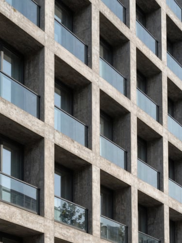 Abstract architectural photography of a modern concrete and glass building facade in Milan, sharp geometric lines, deep shadows, bright daylight, emphasizing structural rigor.