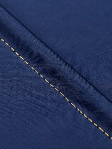 Macro shot of high-end athletic jersey fabric showing precise stitching, deep navy technical fibers with subtle gold weave, crisp studio lighting
