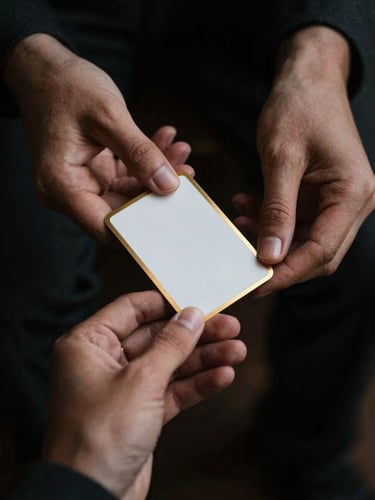 moody editorial photography, dark low-key lighting, hands in a dark charcoal suit holding a pristine, gold-bordered trading card under dramatic warm light, shallow depth of field, 35mm
