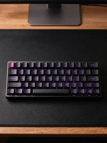 Symmetrical overhead shot of a premium minimalist desk setup, custom mechanical keyboard with subtle purple backlighting, matte black desk mat, diffused warm light