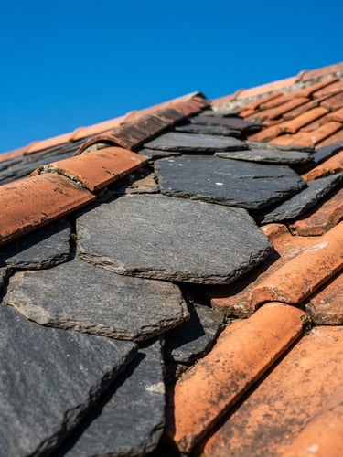 Close-up of clean slate and terracotta roof tiles under bright direct sunlight, vibrant blue sky, high-contrast architectural photography