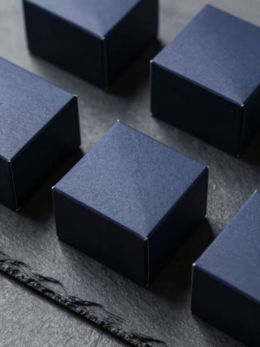 Sleek, high-end consumer goods packaging on a slate surface, crisp studio lighting, deep navy shadows, sharp focus