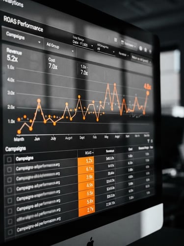 High-resolution close-up of an analytics dashboard displaying ROAS metrics, cool-toned office light, sharp shadows, monochrome with safety orange data points, 35mm lens