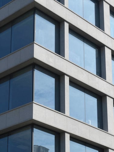 Close-up of clean geometric building facade with sharp shadows under bright natural daylight, corporate blue and gray tones