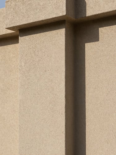 Extreme close-up of premium sand-finish stucco texture, sharp architectural details, natural daylight highlighting the tactile masonry surface.