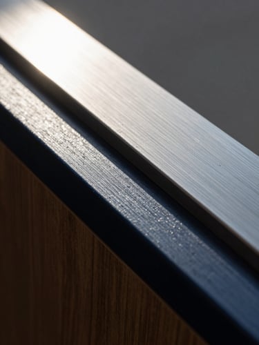 Extreme close-up macro shot of brushed steel and dark navy lacquered wood under hard, directional afternoon sun, casting sharp geometric shadows.
