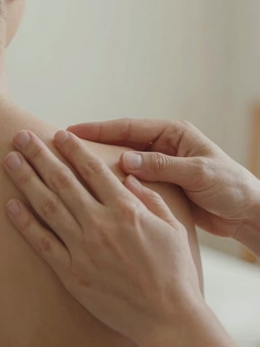 Close-up of hands-on manual therapy, a physiotherapist gently guiding a patient's shoulder movement, warm natural daylight, soft focus, muted earth tones.