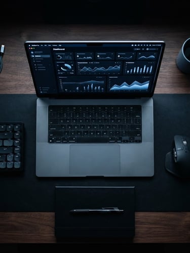 Overhead flat-lay of a clean, quiet workspace. A sleek laptop is open, displaying a structured dashboard with a subtle blue accent glow. Deep black shadows, crisp tech photography style, sharp macro focus, 35mm lens.