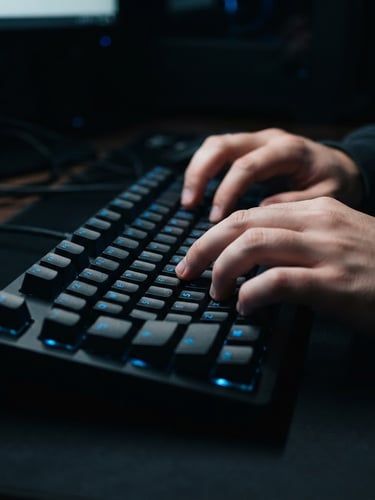 Macro close-up of hands typing on a sleek mechanical keyboard with subtle electric blue backlighting, deep black shadows, crisp technical aesthetic, 35mm lens